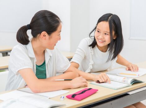 塾で勉強する中学生2人